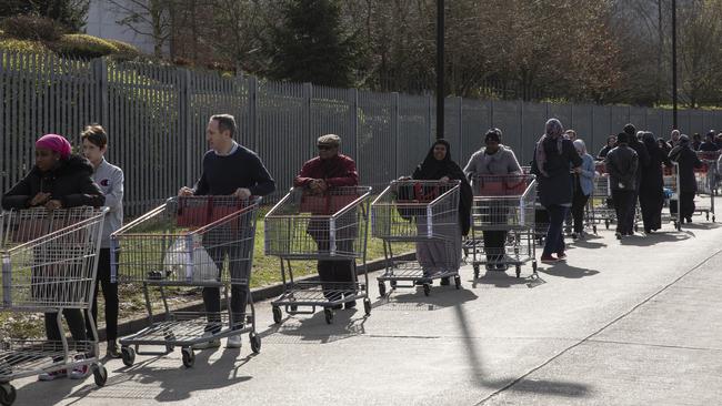 Shoppers form long queues ahead of the opening of a Costco wholesale store in London on March 16.