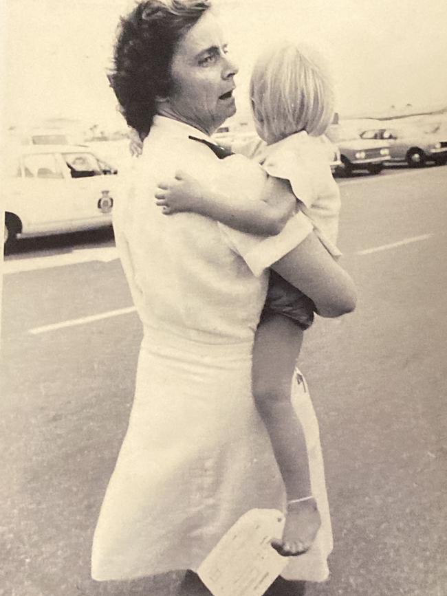 Brenda Brocker is handed to a Salvation Army representative as she is evacuated from Cyclone Tracy.