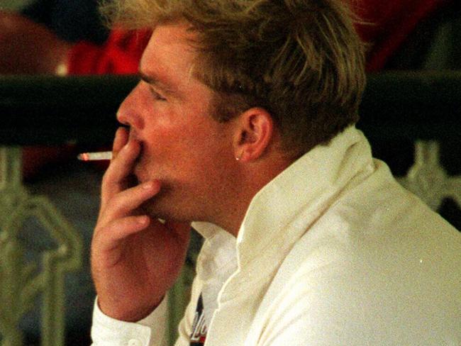 Shane Warne smoking a cigarette in December 1998 while watching a Sheffield Shield match.