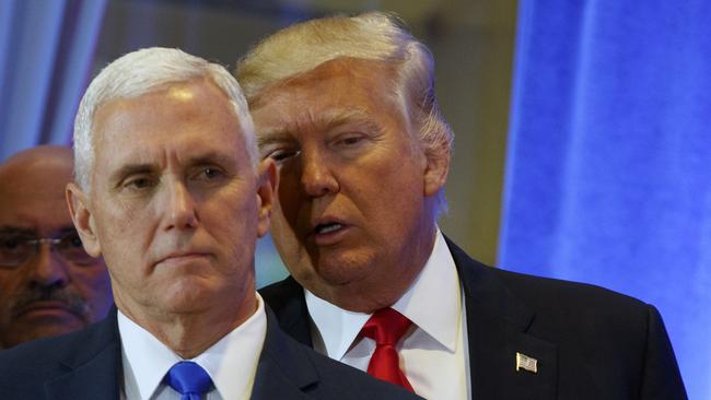 President-elect Donald Trump talks to Vice President-elect Mike Pence during the news conference. picture: AP