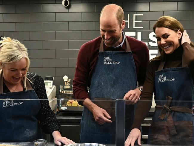 Britain's Prince William, Prince of Wales and Britain's Catherine, Princess of Wales react as prepare to make Welsh Cakes, watched by Theresa Connor, owner of the The Welsh Cake Shop, during a visit to Pontypridd Market, south Wales on February 26, 2025. (Photo by Ben STANSALL / POOL / AFP)