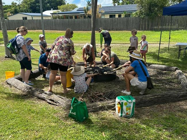 Children and parents cooking damper over the coals during Banksia Scout Group's 2024 Open Day. Damper cooking will again be on offer this Australia Day.