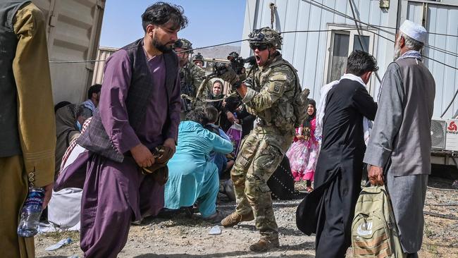 A US soldier points his gun towards an Afghan passenger at the Kabul airport on Monday. Picture: AFP