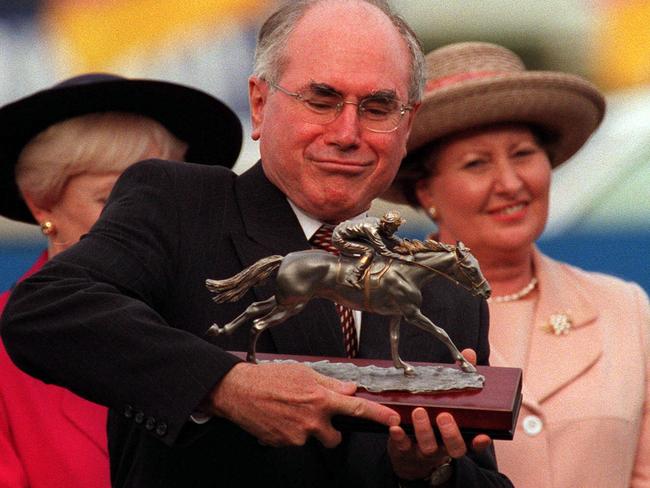 PicAnthony/Weate 19 May 1999 - PM John Howard inspects the trophy during the presentation of the Prime Minister's Cup, at the Gold Coast Turf Club. headshot sport horseracing qld trophy 35/P/14781-14792