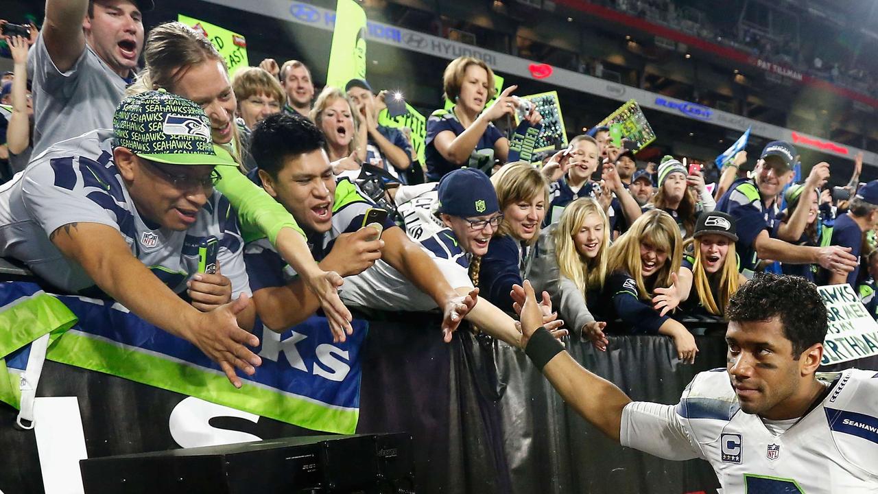GLENDALE, AZ - DECEMBER 21: Quarterback Russell Wilson #3 of the Seattle Seahawks celebrates with fans after defeating the Arizona Cardinals 35-6 in the NFL game at the University of Phoenix Stadium on December 21, 2014 in Glendale, Arizona. Christian Petersen/Getty Images/AFP == FOR NEWSPAPERS, INTERNET, TELCOS & TELEVISION USE ONLY ==