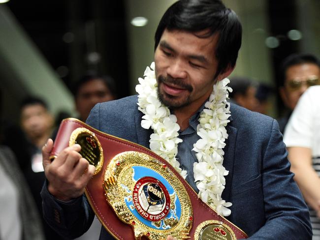 (FILES) This file photo taken on November 8, 2016 shows Philippine boxing icon Manny Pacquiao holding up his welterweight title upon his arrival at the airport in Manila. Manny Pacquiao on February 13, 2017 asked his legions of Twitter followers to choose his opponent after announcing his next world title defence will be in the United Arab Emirates. / AFP PHOTO / Ted ALJIBE