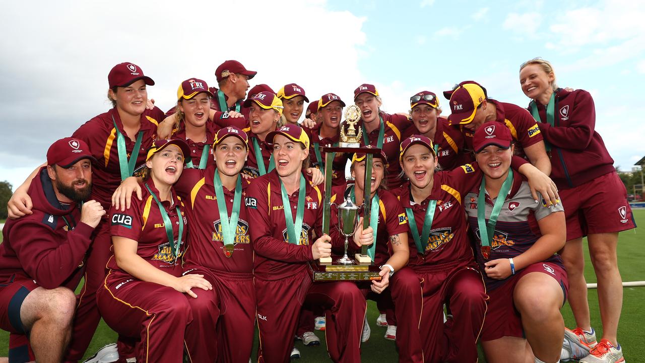 The Queensland Fire players and staff celebrate.