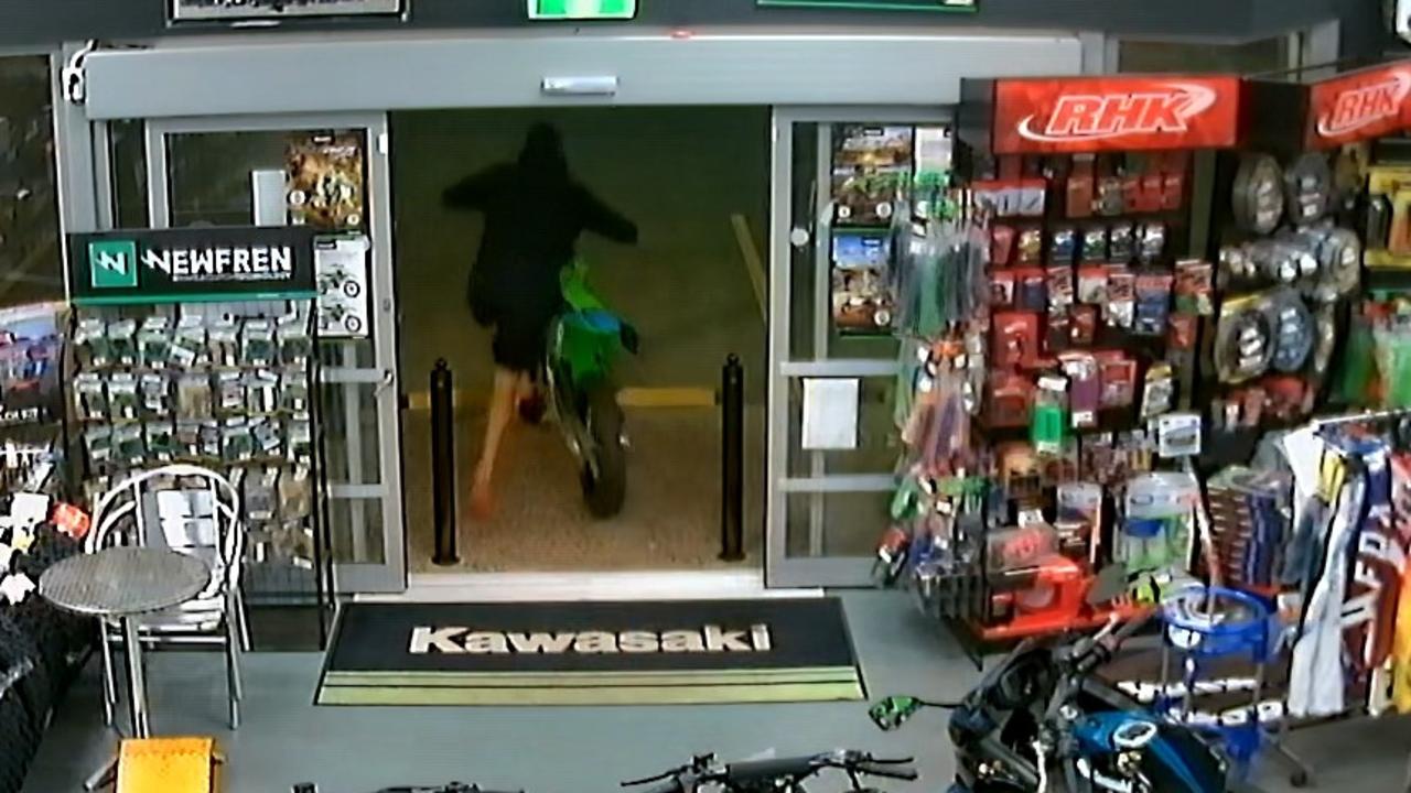 A thief wearing shorts, thongs, gloves and a balaclava smashed into Mackay Kawasaki and stole a bike awaiting pick up from its new owner.