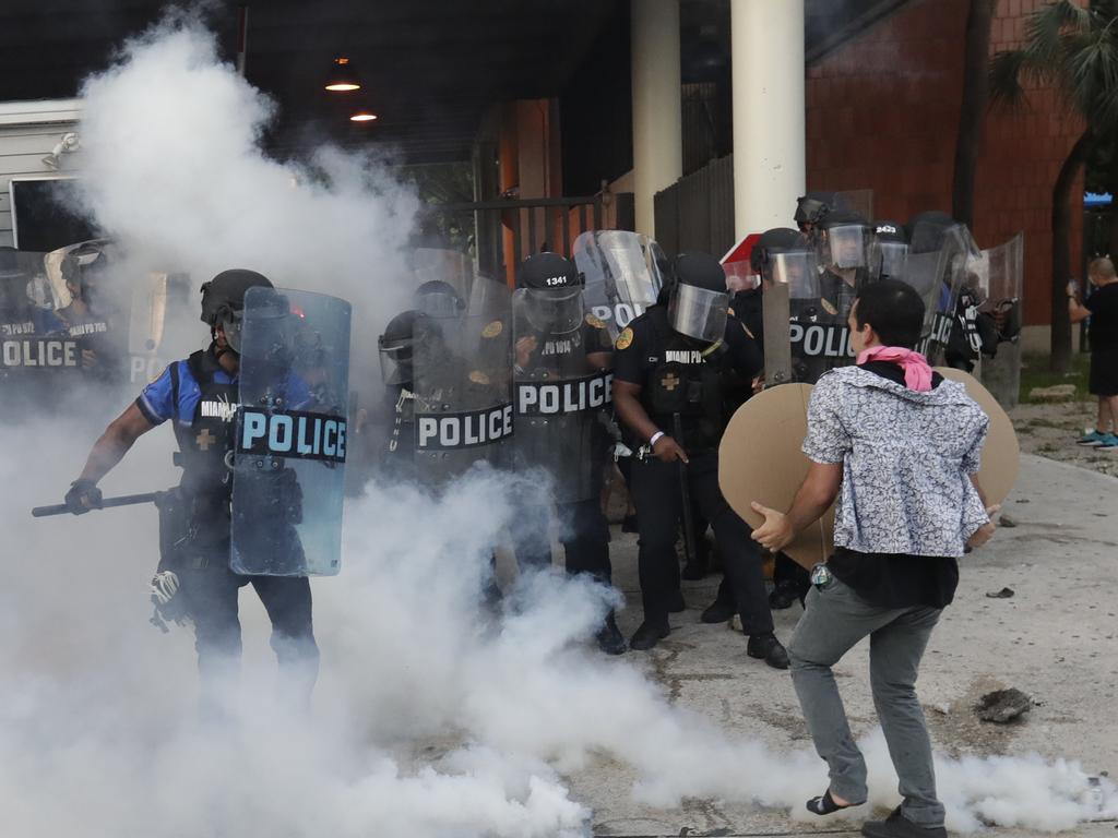 Police react after a demonstrator threw back a tear gas canister during a demonstration next to the city of Miami Police Department. Picture: Wilfredo Lee/AP