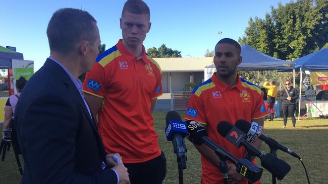 Housing Minister Mick de Brenni talks to Gold Coast Suns players Peter Wright and Touk Miller at the announcement of funding for the club's homeless program. Photo: Kathleen Skene