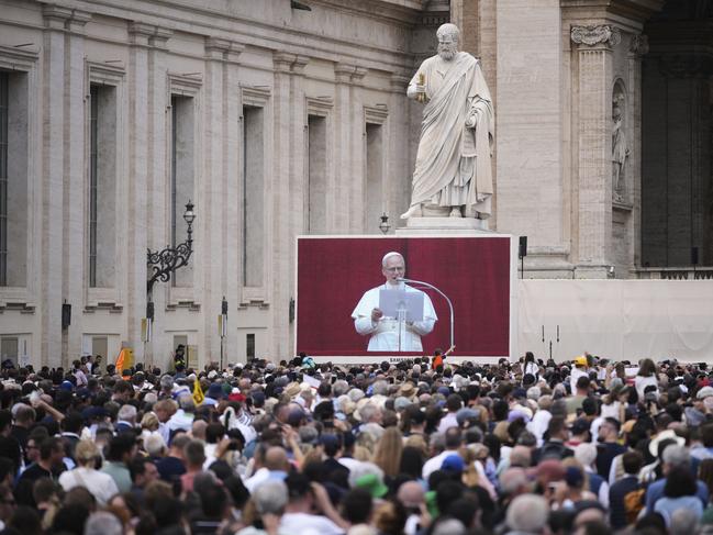 People watch Pope Leo XIV on a giant screen as he delivers his blessing. AP Photo/Andrew Medichini