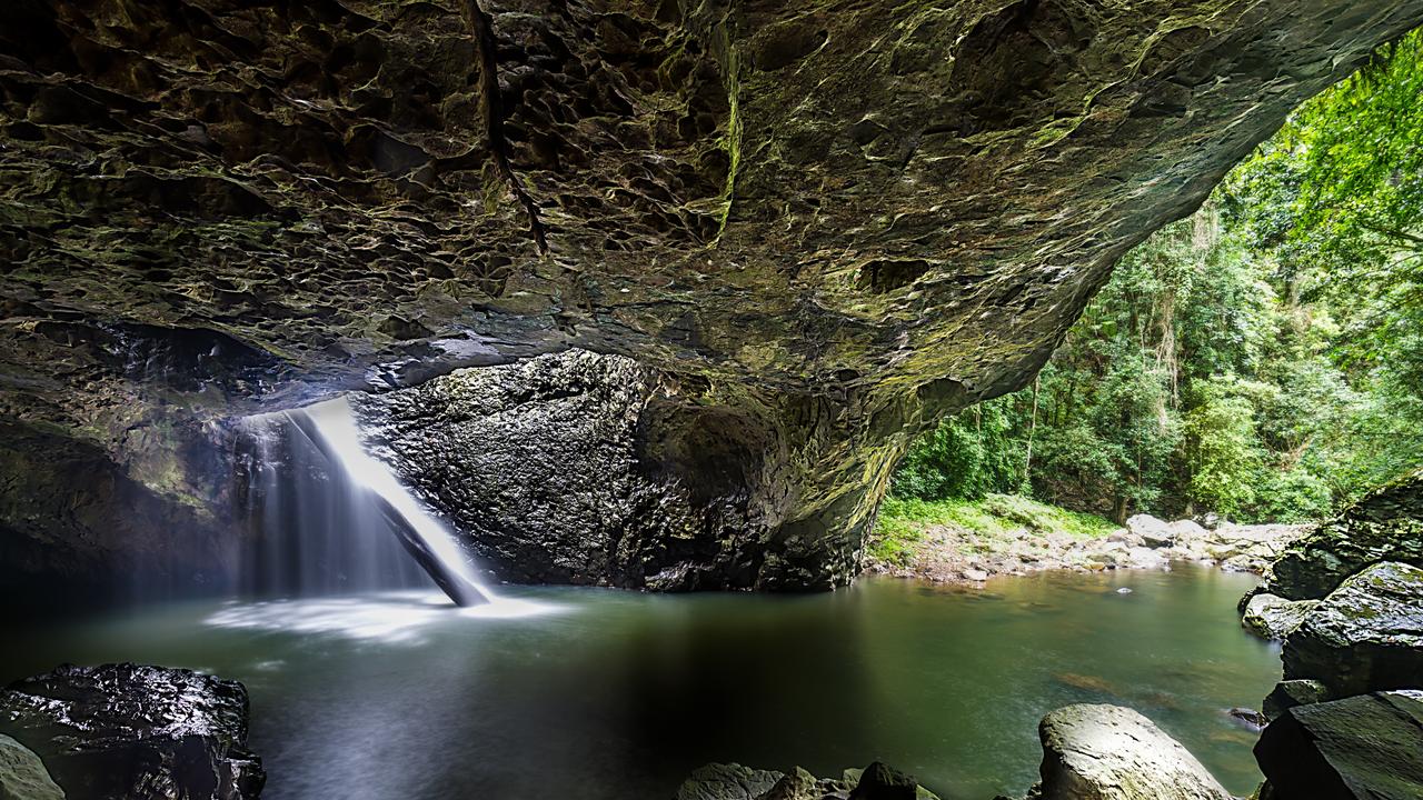 The water streams through a hole in the rock in Springbrook National Park.] Escape 23 March 2025 My Travel CV Photo – iStock