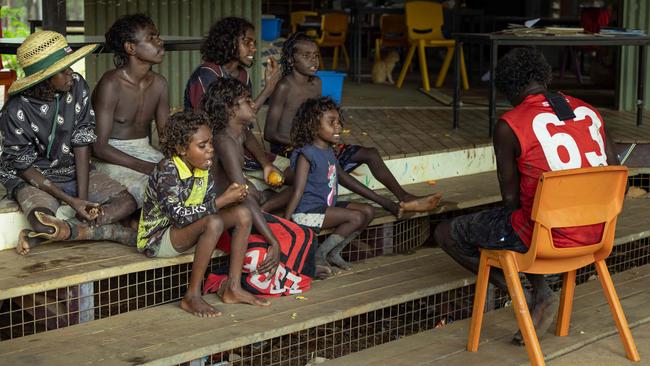 Children enjoying a story on the steps of Gamardi school, as there is no electricity to power the classroom lights and fans. Picture: Rebecca Parker