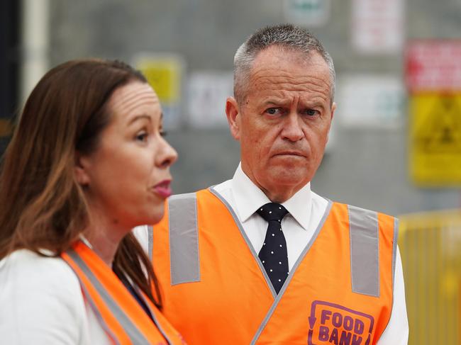 Federal Opposition Leader Bill Shorten looks on as Foodbank chief executive Brianna Casey speaks to the media about the funding cut. Picture: AAP