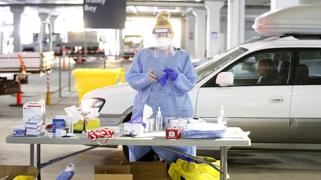 A medical practitioner prepares to administer a test on a member of the public at a drive through testing clinic in the carpark of Bunnings in West Footscray. Picture: Darrian Traynor