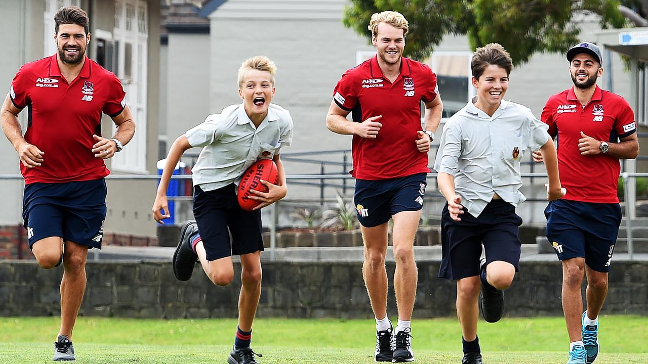 Melbourne Demons players visit their old school Brighton Grammer. Chris Dawes, Jack Watts and Christian Salem kick the footy around with students Felix Flockart (13) and Campbell Tweedie (13). Picture: Jake Nowakowski