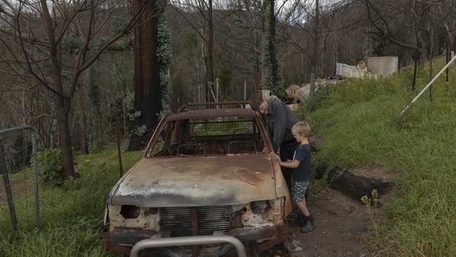 Bushfire survivor Ian Livingston and his son Sydney, 6, are pictured amongst the ruins of their family home in Cobargo, Australia, which was lost to the Black Summer fires.