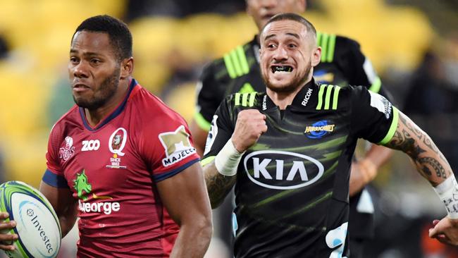 Filipo Daugunu of the Reds (left) runs with the ball ahead of TJ Rerenara of the Hurricanes during the Round 14 Super Rugby match between the Hurricanes and the Queensland Reds at Westpac Stadium in Wellington, New Zealand, Friday, May 18, 2018. (AAP Image/SNPA, Ross Setford) NO ARCHIVING, EDITORIAL USE ONLY