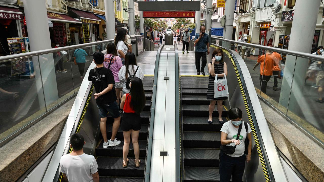 People use the escalator leading to the SMRT subway train station in Chinatown district in Singapore on July 7, 2021. Picture: Roslan RAHMAN / AFP