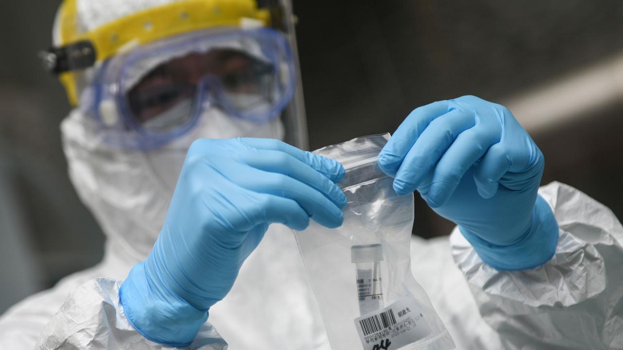 A medical staff member collecting a COVID-19 test sample at a middle school in Guangzhou, China. In April, China did vital work to track and trace COVID-19 cases. Picture: STR/AFP/China OUT.