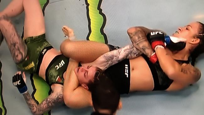 Amanda Nunes latches on a modified triangle and armbar.