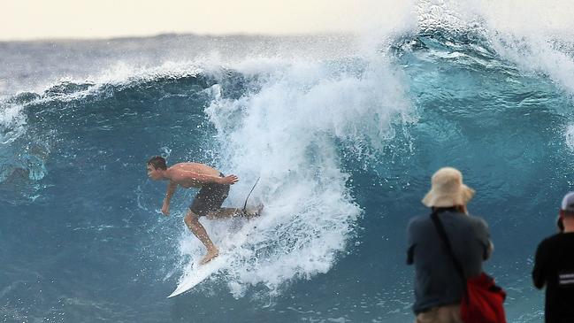 Photographers look on to a surfer at Snapper Rocks on the Gold Coast , Thursday February 21, 2019. Huge swells and high tides are set to pummelling south-east Queensland beaches over the coming days as Cyclone Oma tracks towards the Queensland coast. Photo: Dave Hunt/AAP.