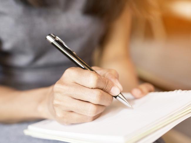 Women holding a pens writing a notebook. Recording concept