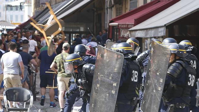 French police officers charge at supporters.