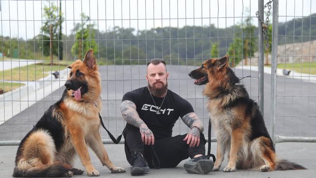 Daniel Lees and his two dogs at Elevate Estate in Ormeau Hills, where he had signed up to purchase land with his ex partner. Picture: Glenn Hampson.