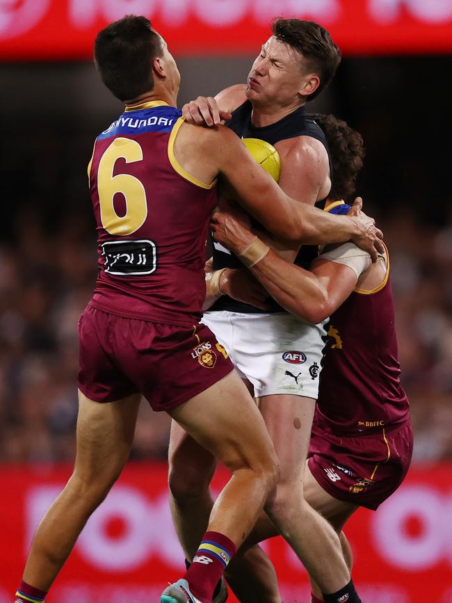 Sam Walsh is tackled by Lions Hugh McCluggage and Jarrod Berry. Picture: Michael Klein.