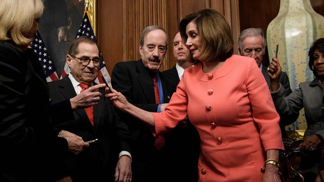 Jerry Nadler looks at a pen as Speaker of the House Nancy Pelosi hands out pens used to sign the articles of impeachment.