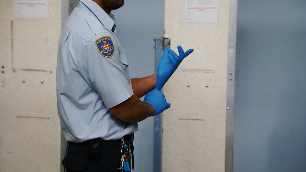 A NSW Corrective Services Officer gets ready for a strip search in the Silverwater processing centre. Picture: Adam Taylor