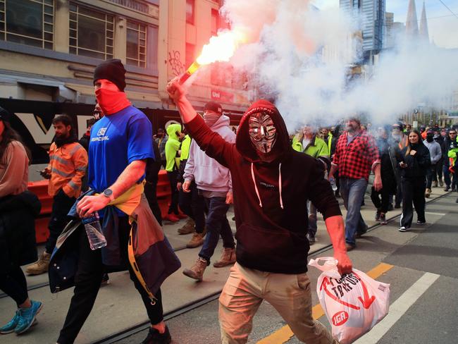 A protester brandishes a flare during the construction worker rally. Picture: Aaron Francis