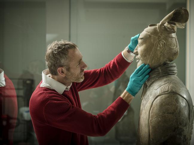 An NGV exhibit team member installing one of the Terracotta Warriors at the NGV. Picture: Eugene Hyland.