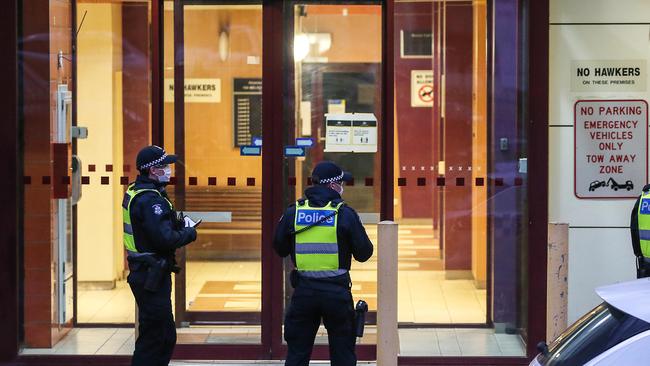 Police guard an entrance to the public housing estate. Picture: Ian Currie