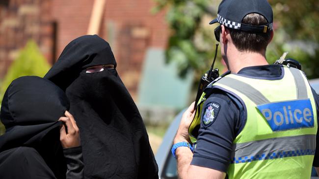 Police speak with two women outside a property raided in Meadow Heights. Picture: Nicole Garmston