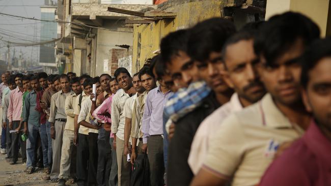 Locals queue to exchange discontinued currency outside a bank in New Delhi.