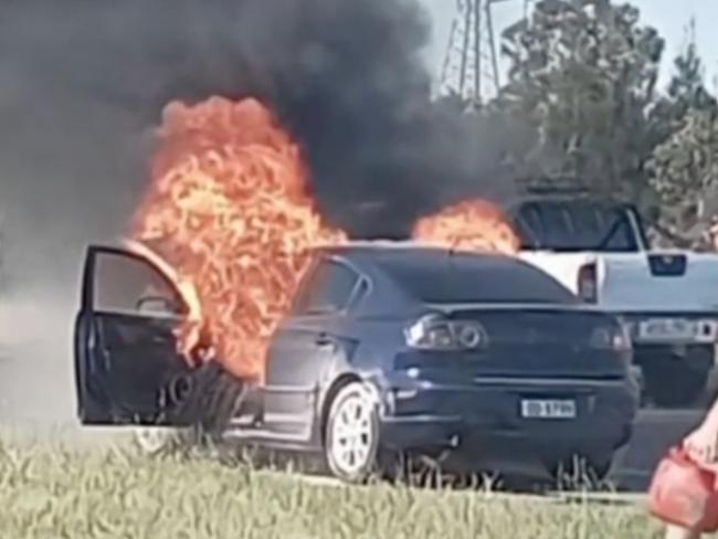 A teenager has told how she leapt from her car moments before it burst into flames on the Salisbury Highway. She had only had the second-hand Mazda for 15 minutes – now, the dealer who sold it to her is under investigation. Picture: 7 NEWS