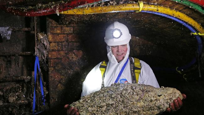 (File photo) Tim Henderson, a "flusher" or trunk sewer technician holds a "fatberg" as he works in the intersection of a sewer. Sewer cleaners fight a grim war against giant "fatbergs" clogging the system. AFP PHOTO / ADRIAN DENNIS / AFP PHOTO / ADRIAN DENNIS