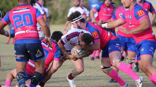 GCDRU (Gold Coast Rugby) first grade clash between Helensvale Hogs (pink) and Nerang Bulls. (white). Jarrod Nyssen tackled by Alex Hatton. Pic Mike Batterham