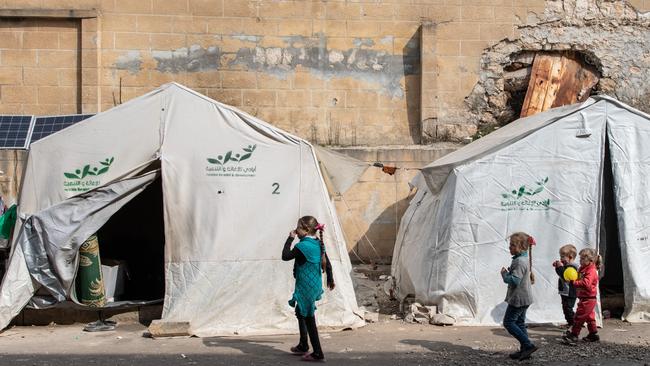 Displaced Syrian children walk past their tents in a stadium which has been turned into a makeshift refugee shelter on in Idlib, Syria, February 2020. Picture: Burak Kara/Getty Images