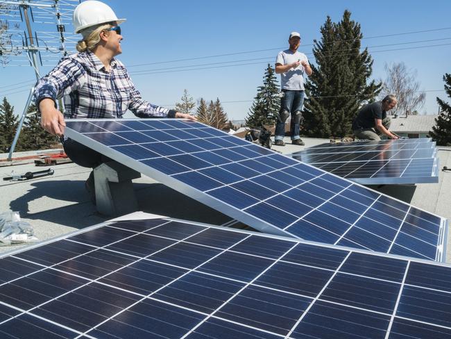 Workers installing solar panels on a residential homes roof.