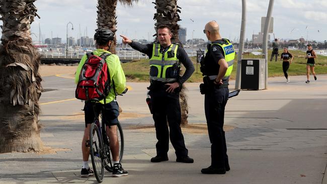 Police patrol Melbourne’s St Kilda Beach Foreshore after the beach was closed under new social distancing rules. Picture: David Geraghty