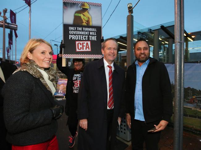 A person holds up a poster referring to the Country Fire Authority (CFA) pay deal behind Opposition leader Bill Shorten. Picture: Kym Smith/AAP