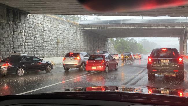 Motorists seek shelter from the hail on the Pacific Motorway on the Gold Coast.