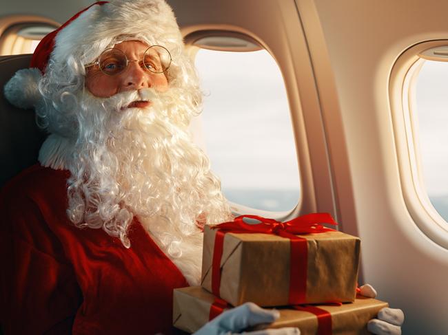 Santa Claus with gift boxes sitting on board the plane. Picture: iStock