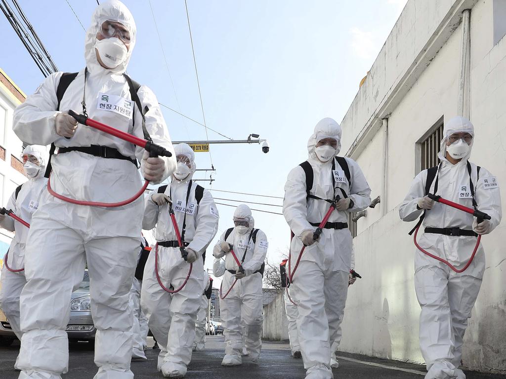 South Korean army soldiers wearing protective gears spray disinfectant as a precaution against the new coronavirus on a street in Gyeongan, South Korea. Picture: Kim Hyun-tae/Yonhap via AP
