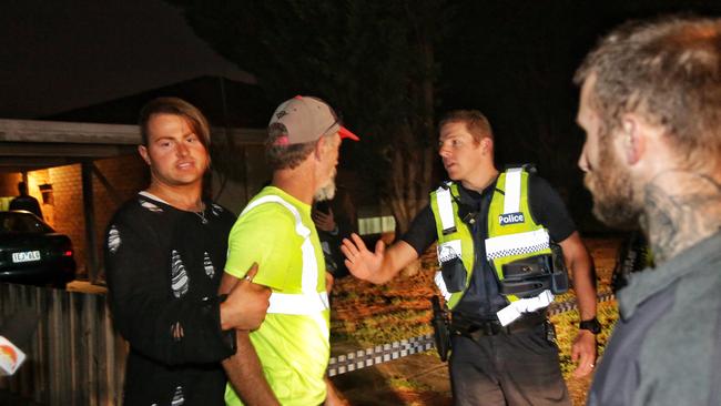 Ms Stuart’s partner is restrained as he speaks to a police officer. Picture: Hamish Blair