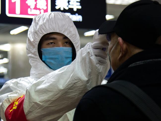 BEIJING, CHINA - JANUARY 26: A health worker checks the temperature of a man entering the subway on January 26, 2020 in Beijing, China. The number of cases of coronavirus rose to 1,975 in mainland China on Sunday. Authorities tightened restrictions on travel and tourism this weekend after putting Wuhan, the capital of Hubei province, under quarantine on Thursday. The spread of the virus corresponds with the first days of the Spring Festival, which is one of the biggest domestic travel weeks of the year in China. Popular tourism landmarks in Beijing including the Forbidden City, Badaling Great Wall, and The Palace Museum were closed to the public starting Saturday. The Beijing Municipal Education Commission announced it will delay reopening schools from kindergarten to university. The death toll on Sunday rose to 56. The majority of fatalities are in Wuhan where the first cases of the virus were reported last month. (Photo by Betsy Joles/Getty Images)