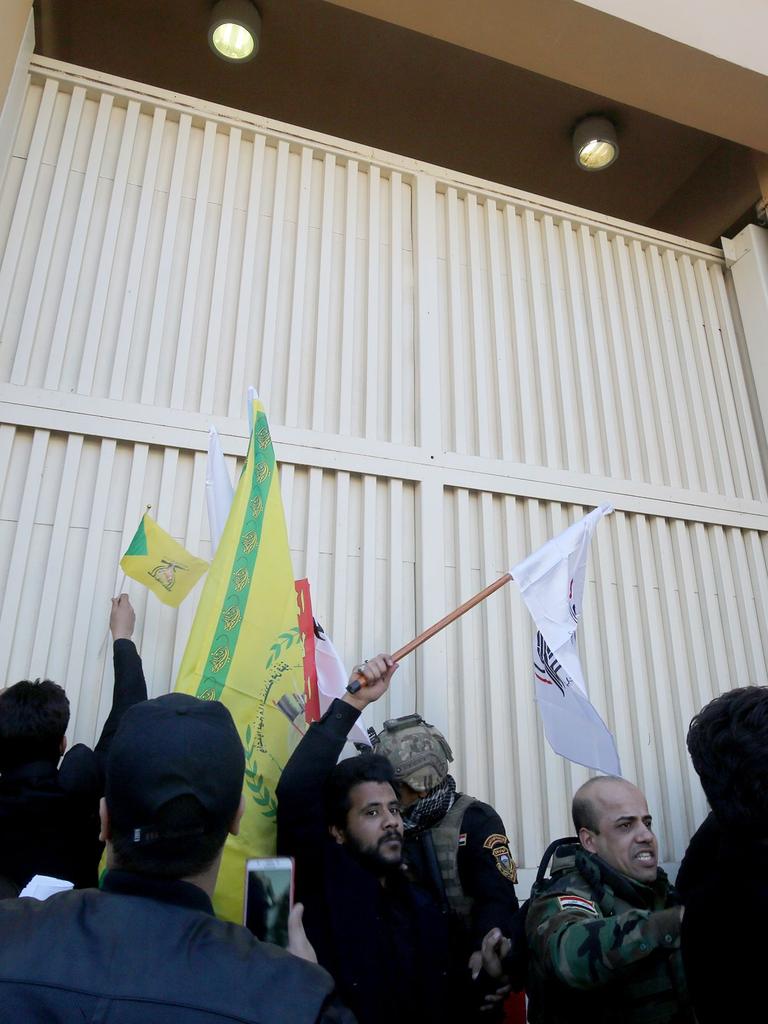 Members of Iraq's security forces try to keep protesters away from on of the gates of the US embassy after they breached the outer wall of the diplomatic mission in Baghdad. Picture: AFP